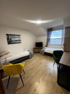 - une chambre avec deux lits et une chaise jaune dans l'établissement Terminal, à Poznań