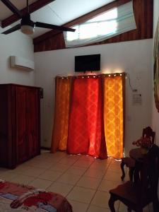 two curtains in a room with a television on top at Las cabinas del sueño in Nicoya