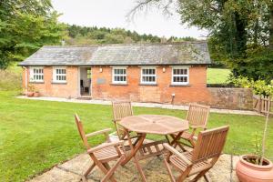 a wooden table and chairs in front of a house at Piglets Retreat in Budleigh Salterton