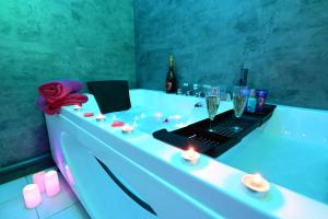 a bathroom with a bath tub with a laptop on it at Love Room à deux pas de l'Océan avec Hammam, Sauna et Bain à 2 :-) in Biscarrosse