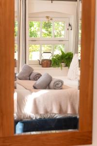 a mirror reflecting a bed in a room with a window at Piglets Retreat in Budleigh Salterton