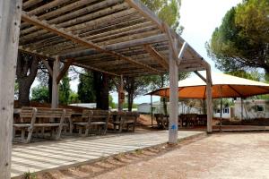 a wooden pavilion with wooden tables and umbrellas at Mobilhome Clermont Auvergne Climatisé in Sigean