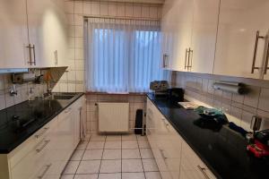a kitchen with white cabinets and a black counter top at Charmant Appart. dans une Villa in Saint-Louis +7 photos