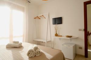 a white bedroom with a bed with towels on it at Darrere del port in Alghero