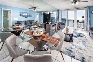 een woonkamer met een glazen tafel en stoelen bij Nautilus 1402 - Gulf Front 1 Bedroom - 4th Floor in Fort Walton Beach