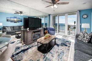 a living room with a tv and a couch and a fireplace at Nautilus 1402 - Gulf Front 1 Bedroom - 4th Floor in Fort Walton Beach