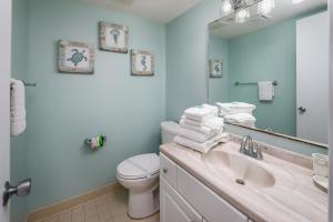 a bathroom with a sink and a toilet and a mirror at Nautilus 1402 - Gulf Front 1 Bedroom - 4th Floor in Fort Walton Beach