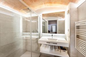 bagno con lavandino e specchio di C&C Apartments a Figueres