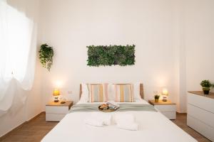 1 dormitorio con 1 cama blanca grande y 2 mesitas de noche en Isonzo House en Bari