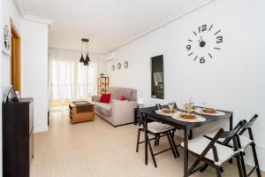 RELAX في توريفايجا: غرفة معيشة مع طاولة وكراسي وساعة