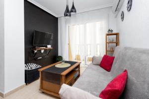 uma sala de estar com um sofá e uma televisão em RELAX em Torrevieja