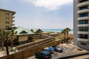two cars parked in a parking lot next to a building at Nautilus 2308 Gulf View 2 Bedroom 3rd Floor Free Beach Service in Fort Walton Beach