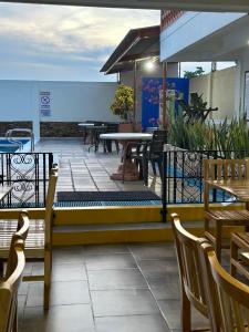 un patio con mesas, sillas y una mesa. en Monteverde Hotel, en La Dorada