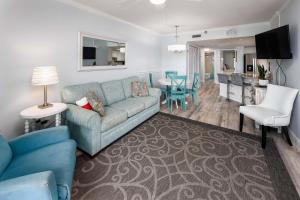sala de estar con sofá azul y cocina en Nautilus 2308 Gulf View 2 Bedroom 3rd Floor Free Beach Service en Fort Walton Beach