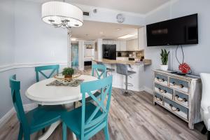 a kitchen and dining room with a white table and blue chairs at Nautilus 2308 Gulf View 2 Bedroom 3rd Floor Free Beach Service in Fort Walton Beach