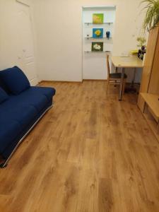 ein Wohnzimmer mit einem blauen Sofa und einem Tisch in der Unterkunft Apartamenti dzīvoklis Ogre. in Ogre