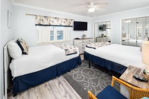 a bedroom with two beds and a table and a tv at Nautilus 2308 Gulf View 2 Bedroom 3rd Floor Free Beach Service in Fort Walton Beach