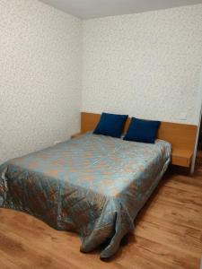Bett mit blauen Kissen in einem Zimmer in der Unterkunft Apartamenti dzīvoklis Ogre. in Ogre