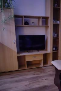 een flatscreen-tv op een houten entertainmentcentrum bij Apartamenti dzīvoklis Ogre. in Ogre