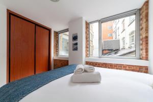 1 dormitorio con 1 cama con 2 toallas en Elegance & Chic Design - 2-bedroom Haven, en Londres