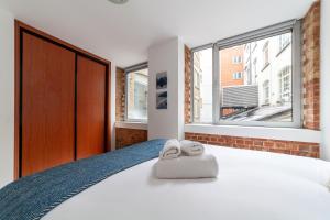 a bedroom with a bed with two towels on it at Elegance & Chic Design - 2-bedroom Haven in London