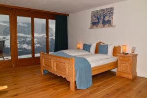 a bedroom with a large bed with blue pillows at Ferienwohnungen Hotel Bellevue in Seelisberg