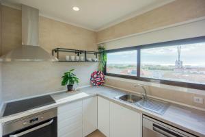 cocina con fregadero y ventana en Beach Apartment w/Ocean view en Costa da Caparica