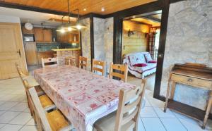 ein Esszimmer mit einem Tisch und einer Küche in der Unterkunft L'ECHO DE LA CORNE in La Chapelle-dʼAbondance