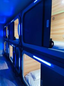 - un ensemble de lits superposés dans un dortoir avec des lumières bleues dans l'établissement KAMA CENTRAL PARK, à New York
