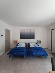 2 Betten in einem Zimmer mit einem TV an der Wand in der Unterkunft Villa Laura Holiday House in Bologna