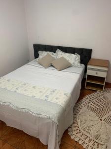 a bed with two pillows on it in a bedroom at Edícula tranquila e bem localizada no Butantã in São Paulo