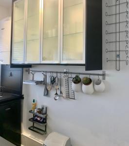 a kitchen with black and white cabinets and plants at DIDSBURY Fáilte Inn Apts - 3 Mins to The Christie's - Ground Floor - FREE Parking in Manchester