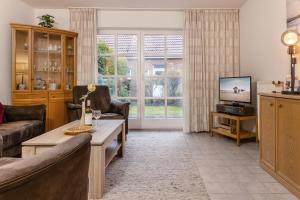 ein Wohnzimmer mit Couch und Fernseher in der Unterkunft 50158... in Carolinensiel