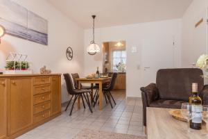 eine Küche und ein Wohnzimmer mit einer Couch und einem Tisch in der Unterkunft 50158... in Carolinensiel