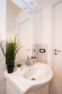 W białej łazience znajduje się umywalka i lustro. w obiekcie Karafa w mieście Bari