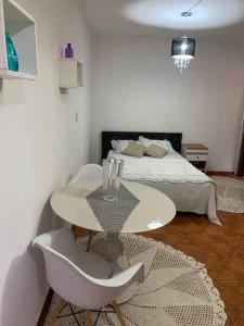 um quarto branco com uma cama, uma mesa e cadeiras em Edícula tranquila e bem localizada no Butantã em São Paulo