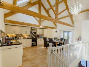 a kitchen and dining room with wooden floors and beams at 3 Bed in Shebbear 89311 in Shebbear