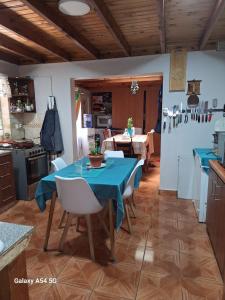 cocina y comedor con mesa azul y sillas en Familia Flores Sáez, en Parral