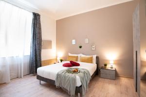 sypialnia z dużym białym łóżkiem z czerwonymi poduszkami w obiekcie Karafa w mieście Bari