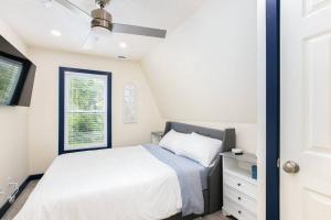 1 dormitorio con cama blanca y ventana en Walk to ND, Hot Tub, Lux Kitchen, Pet Friendly, en South Bend
