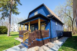 a blue tiny house with a wooden porch at Walk to ND, Hot Tub, Lux Kitchen, Pet Friendly in South Bend