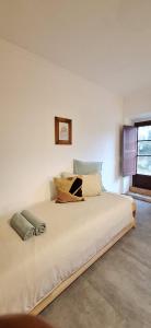 a bedroom with a large white bed with pillows on it at Casa Bonabal- 15 min from Ericeira 