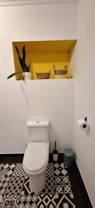 a bathroom with a white toilet and a black and white tile floor at Casa Bonabal- 15 min from Ericeira 