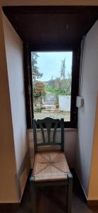 a chair sitting in a room with a window at Casa Bonabal- 15 min from Ericeira 