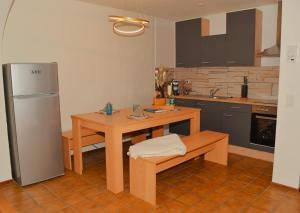 cocina con mesa de madera y nevera en Ferienwohnungen Hotel Bellevue, en Seelisberg