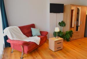 a living room with a red couch and a table at Ferienwohnungen Hotel Bellevue in Seelisberg