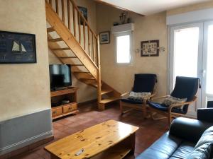 a living room with a couch and a staircase at Maison avec piscine pres de l'ocean in Saint-Trojan-les-Bains