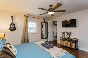 a bedroom with a blue bed and a ceiling fan at The Johnny and June House Prime Location in Nashville