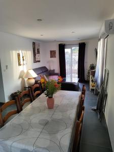 a dining room table with a vase of flowers on it at Villa collections appartement trois chambres a partager ou pas in Vergèze