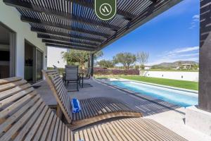 une terrasse avec bancs et une piscine dans l'établissement CSL Country Club, à Cabo San Lucas